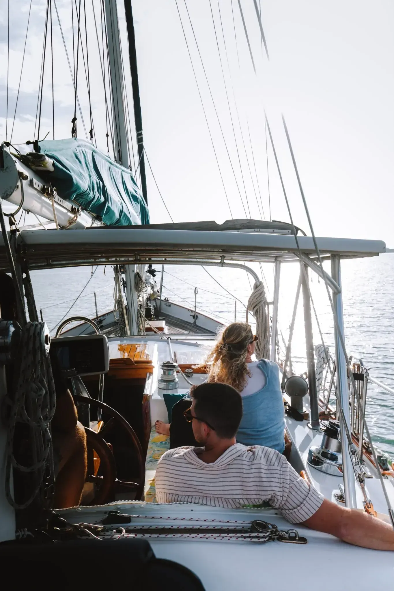 Couple relaxing in the cockpit at golden hour aboard SV Cay Michele